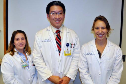 three people in white coats posing for a photo