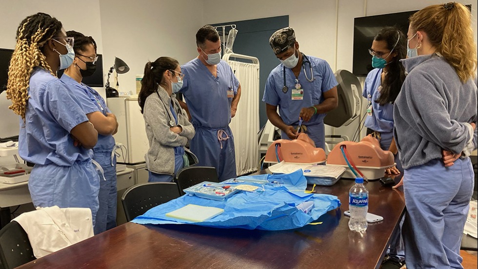 doctors watching a surgical task performed on a dummy