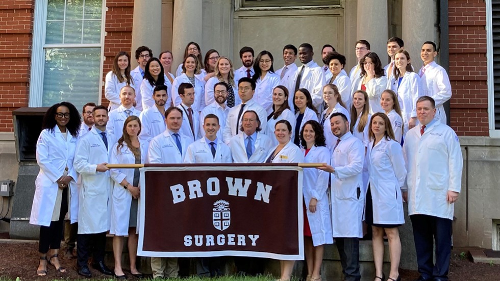 group of people posing for a photo with a Brown Surgery banner